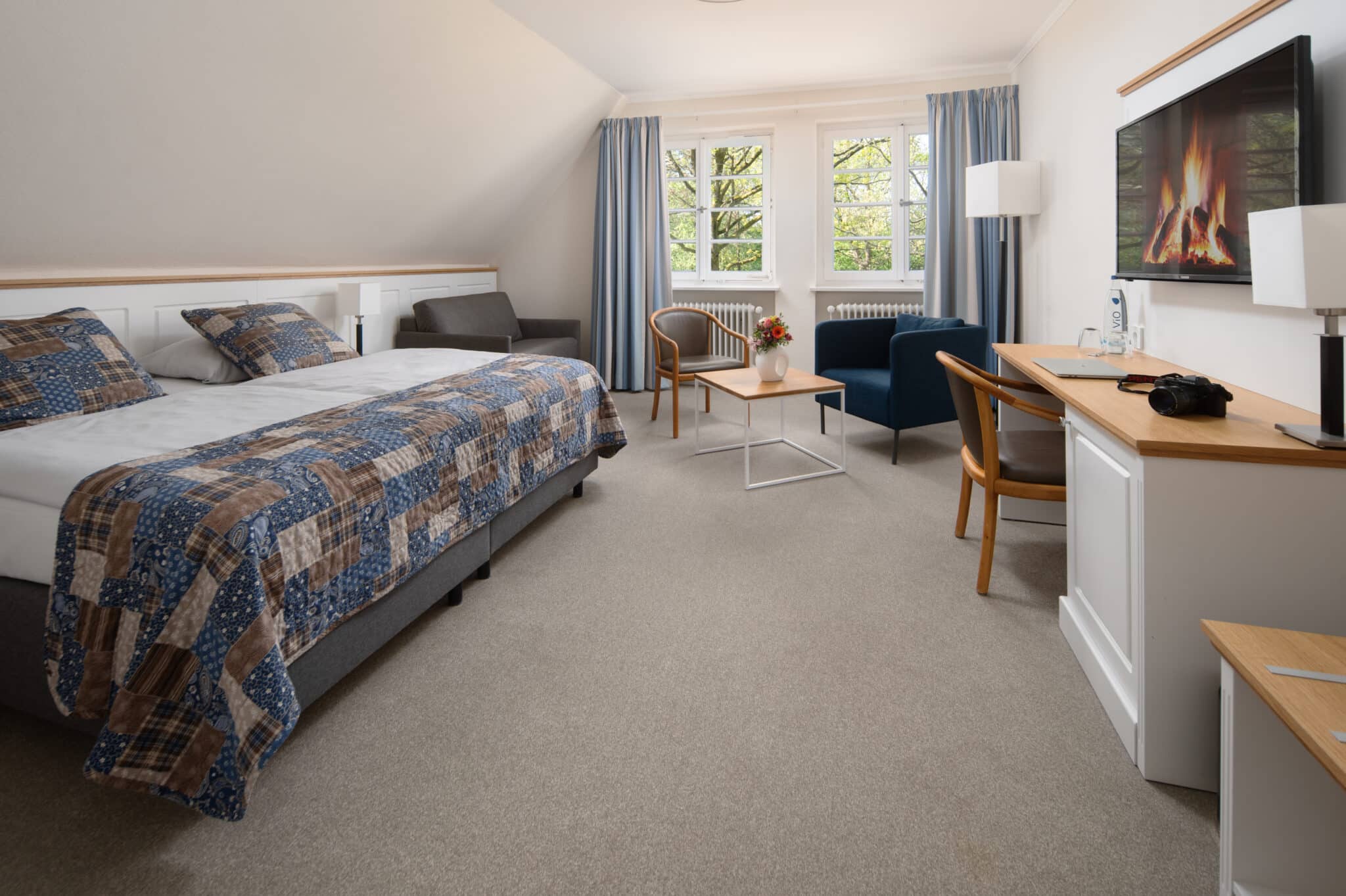 Hotelzimmer mit Bett, Schreibtisch und Sitzgelegenheit vor dem Fenster