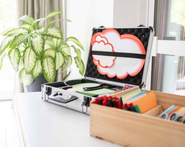 Aufgeklappter Moderationskoffer und Karteikarten mit Flipchart-Stiften