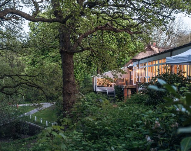 Außenaufnahme des Gebäudes in der Abenddämmerung mit seitlichem Blick auf die Alster