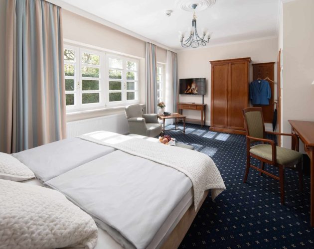 Zimmer im Hotel Mellingburger Schleuse mit Terrassentür und blauem Teppichboden