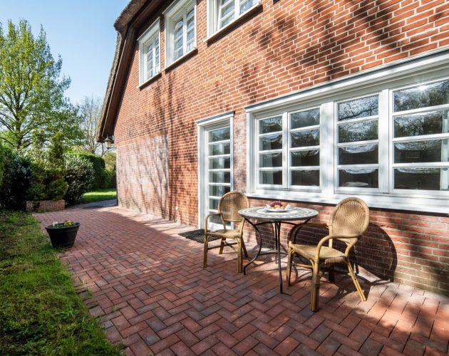 Zu einem Hotelzimmer gehörende Terrasse mit zwei Stühlen und einem kleinen runden Tisch