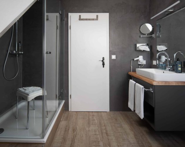 Badezimmer mit Dusche und Waschtisch im Hotel Mellingburger Schleuse