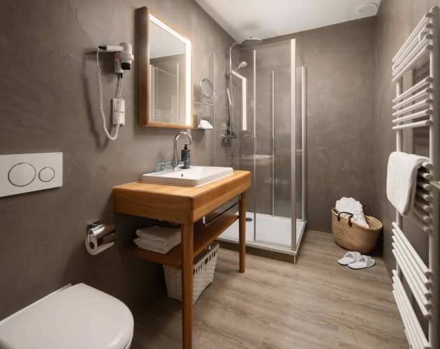 Badezimmer mit Dusche und Waschtisch aus Holz im Hotel Mellingburger Schleuse