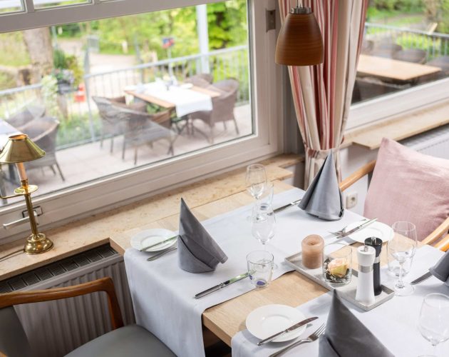 Eingedeckter Tisch am Fenster im Restaurant im Hotel Mellingburger Schleuse
